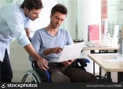 Businessman in wheelchair with laptop computer