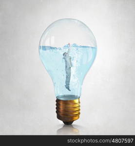 Businessman inside bulb. Glass light bulb filled with clear water and businessman inside