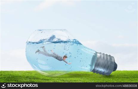 Businessman inside bulb. Glass light bulb filled with clear water and businessman inside