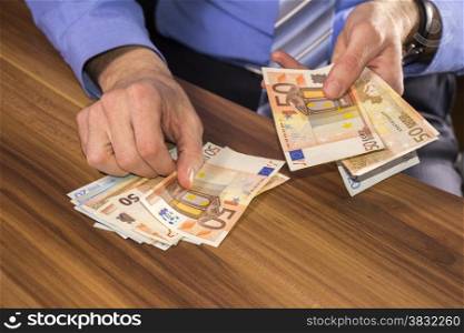 Businessman is counting euro banknotes, business and financial background