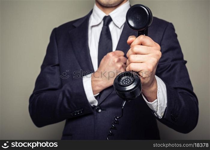Businessman is handing over a telephone receiver