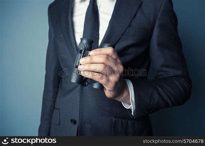 Businessman is holding binoculars