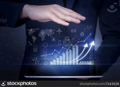 Businessman is holding financial growth graph and analyzing business data, business plan and strategy concept .