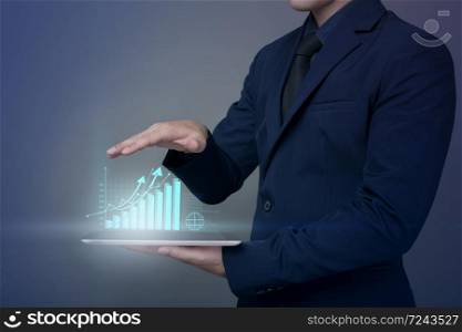 Businessman is holding financial growth graph and analyzing business data, business plan and strategy concept .