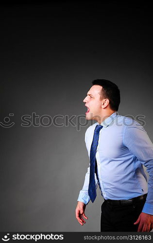 businessman is screaming on dark background