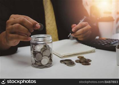 businessman is shown holding a jar with coins for savings and investments. Concept of tax payments and business accounting.