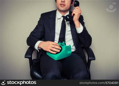 Businessman is sitting in an office chair and is on the phone