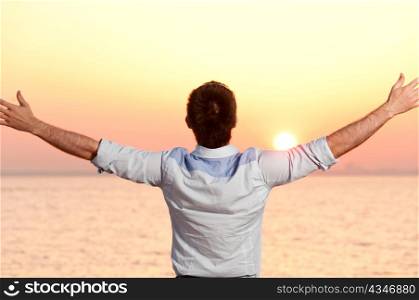 businessman is standing near the sea at sunrise