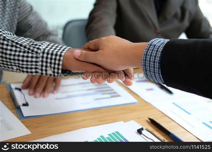 businessman joining united hand, business team touching hands together after complete a deal in meeting. unity teamwork partnership corporate concept.