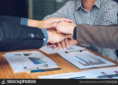 businessman joining united hand, business team touching hands together after complete a deal in meeting. unity teamwork partnership corporate concept.