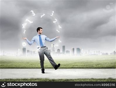 Businessman juggler. Young businessman juggling with numerals against city background