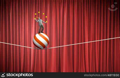 Businessman juggling with balls. Young businessman standing on ball juggling with balls