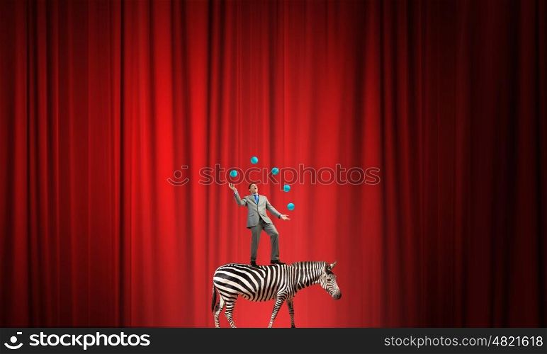 Businessman juggling with balls. Young businessman standing on zebra and juggling with balls
