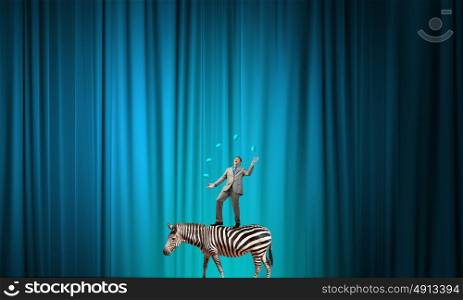 Businessman juggling with balls. Young businessman standing on zebra and juggling with balls