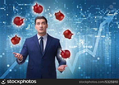 Businessman juggling with piggybanks in business concept