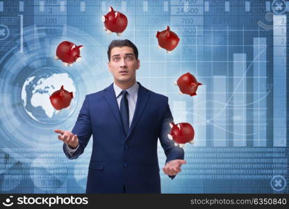 Businessman juggling with piggybanks in business concept