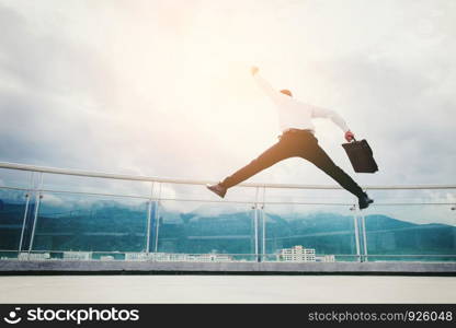 Businessman Jump on a roof and looking at city Success concept