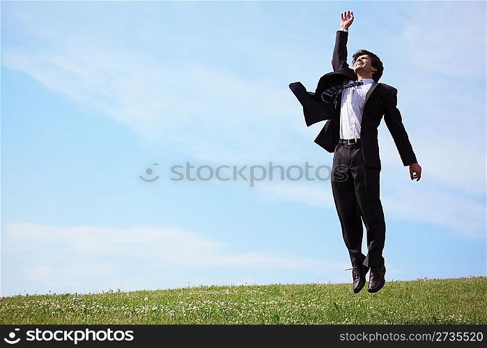 businessman jumping on grass