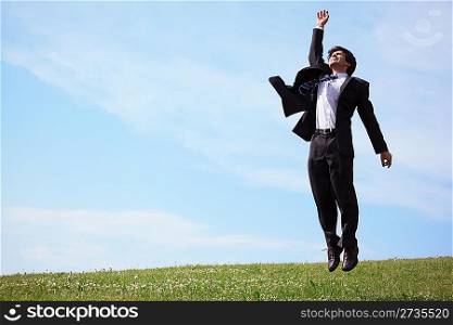 businessman jumping on grass