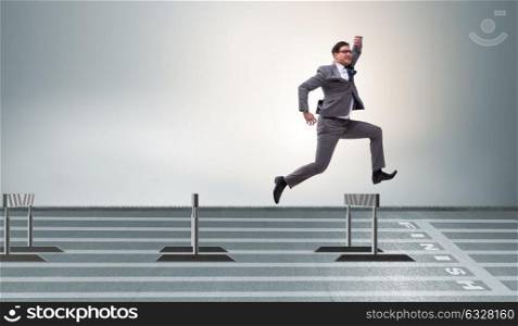 Businessman jumping over barriers in business concept