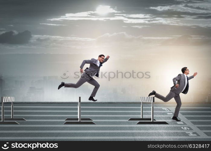 Businessman jumping over barriers in business concept