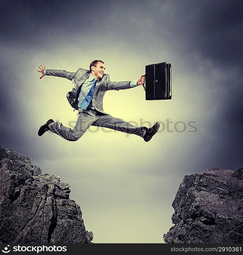 Businessman jumping over gap