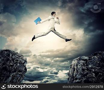 Businessman jumping over gap