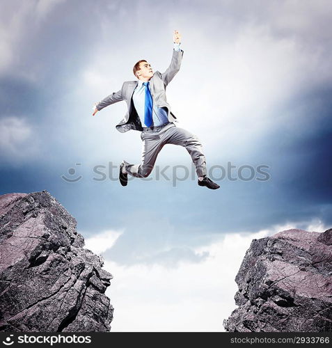 Businessman jumping over gap