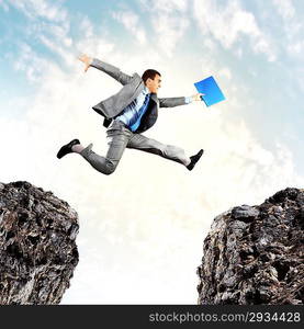 Businessman jumping over gap