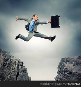 Businessman jumping over gap