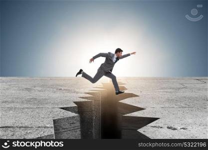 Businessman jumping over the cliff