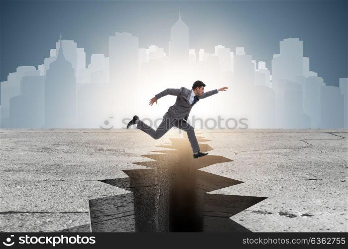 Businessman jumping over the cliff