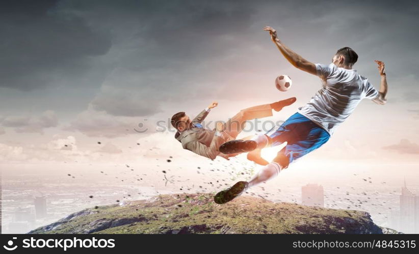 Businessman kicking ball. Young businessman in suit playing football outdoors