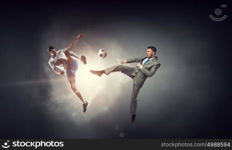 Businessman kicking ball. Young businessman in suit playing football outdoors