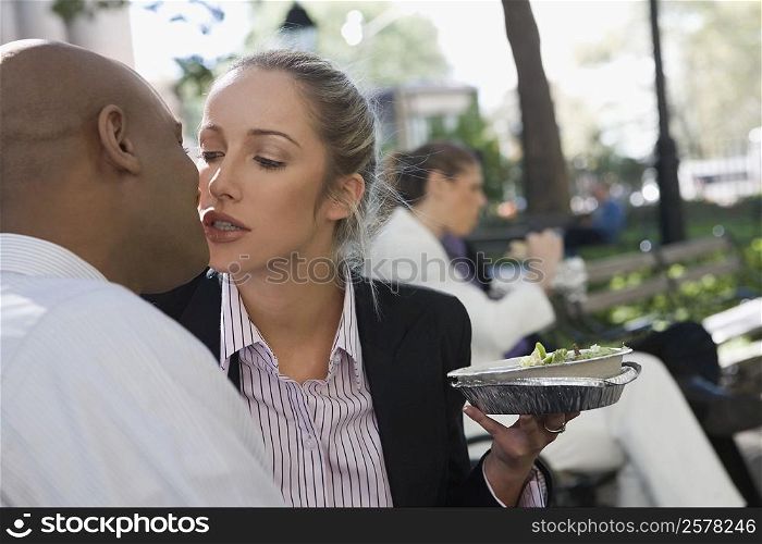 Businessman kissing a businesswoman