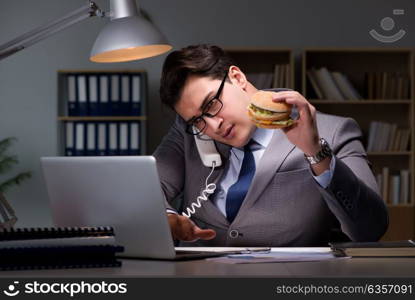 Businessman late at night eating a burger