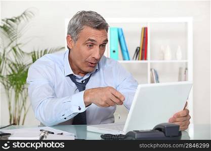 Businessman laughing in front of a laptop