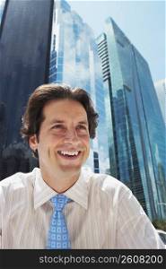 Businessman laughing in front of office buildings
