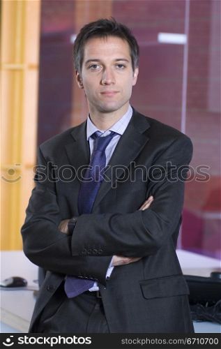 Businessman leaning against a table in an office