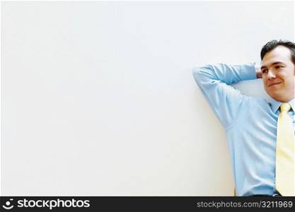 Businessman leaning against a wall and smiling