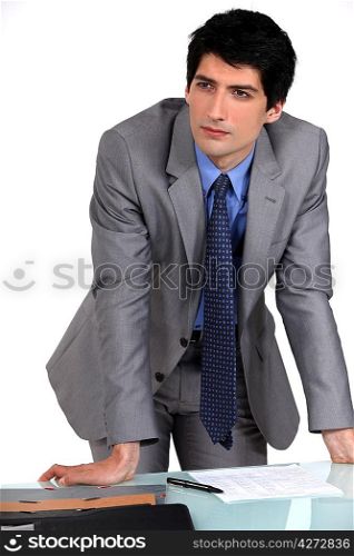 Businessman leaning on his desk