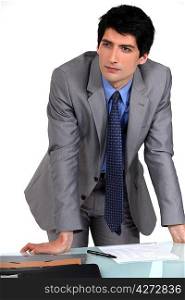Businessman leaning on his desk