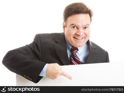 Businessman leaning over blank white space, pointing, with a big smile.