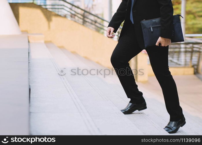 businessman legs walking the stairs in modern city.