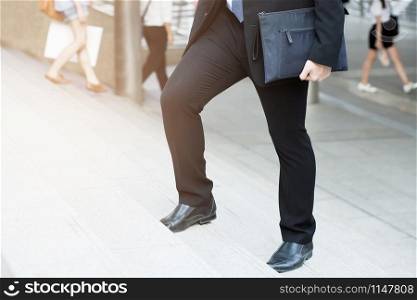 businessman legs walking the stairs in modern city.
