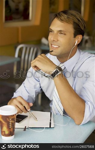 Businessman listening to an MP3 player and smiling