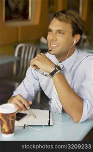 Businessman listening to an MP3 player and smiling