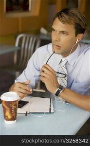 Businessman listening to an MP3 player and thinking