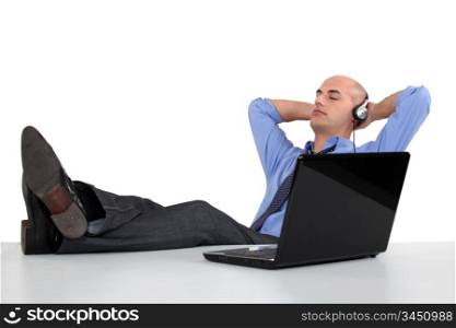 Businessman listening to music on his computer