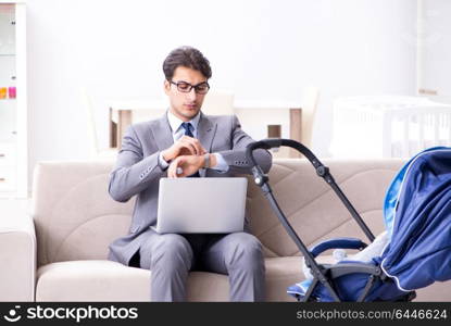 Businessman looking after newborn baby at home and teleworking